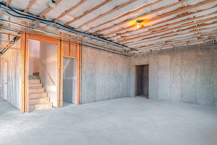 Unfinished basement with concrete floor and exposed foundation walls